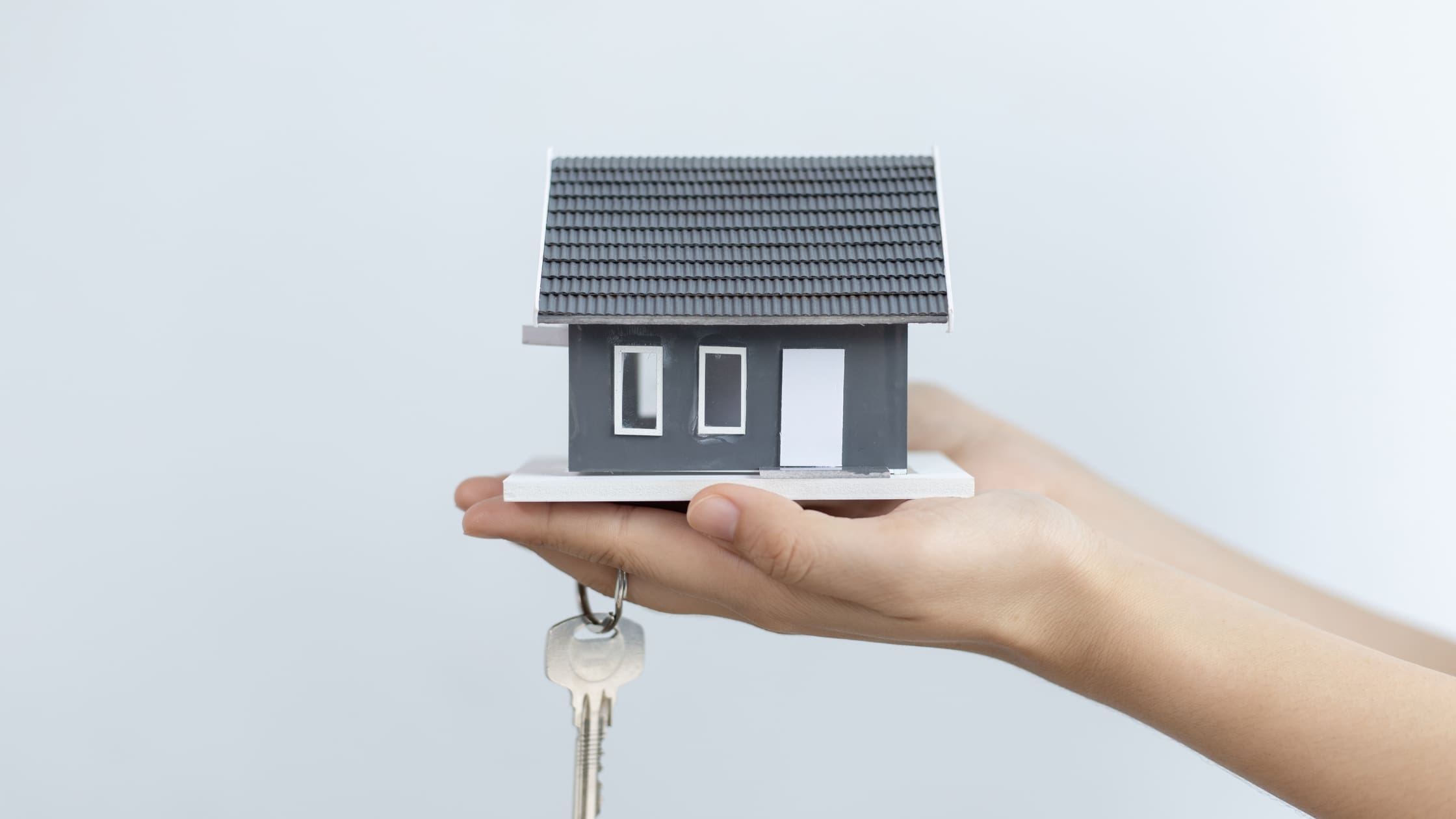 Why Invest in Property Development (Blog post) Hand holding a small house
